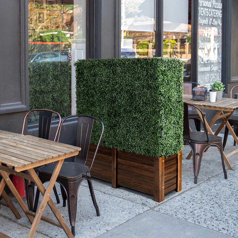 Artigwall's artificial boxwood hedge in wood planter outside of store