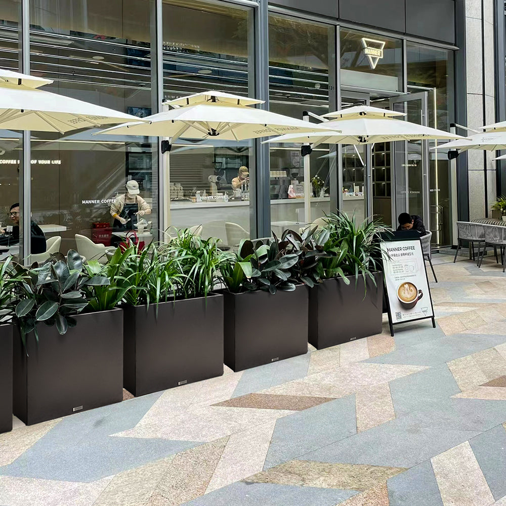 Large rectangular black metal planter box by Artigwall outside of business
